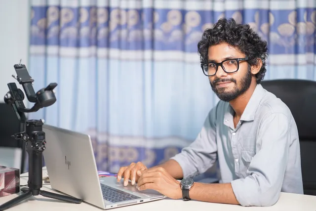 Portrait of a web developer working on a laptop, showcasing technical and professional skills. Local web design agency vs remote: which works for UK businesses?
