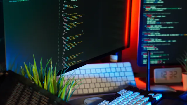 A vibrant workspace showing computer monitors with code, keyboard, and tech accessories. Best tools for web design agencies: five categories with exact editions