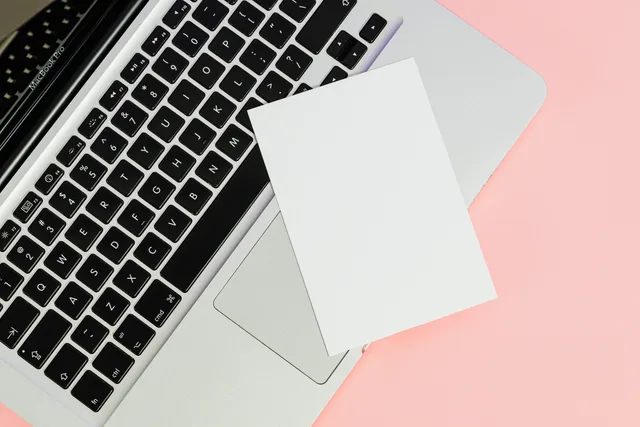 A blank card placed on a laptop keyboard with ample copy space on a pastel background. Buyer hypothesis cards for web design agencies: fields and confidence