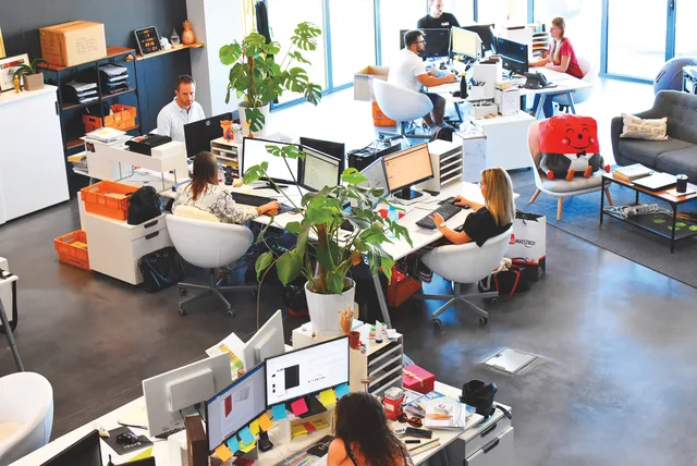 A vibrant modern office with employees collaborating at their desks. Web design agencies commercial opportunities: five niches