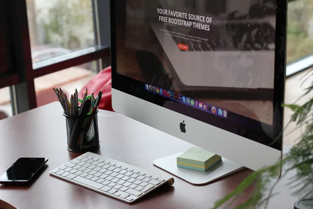 A clean, organized desk setup featuring a computer display, keyboard, and office supplies. Web design agencies pricing models: charge units and risk
