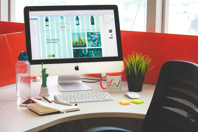 A contemporary office desk setup with a computer, accessories, and vivid colors. Vetting a web design agency's tools and suppliers in the UK